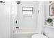 Freshly renovated bathroom with a combined shower and bathtub, featuring a built-in niche and window at 1731 Clearwater Harbor Dr, Largo, FL 33770