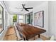 Bright dining room with a large wooden table, white chairs, and windows offering a view of the outdoors at 1731 Clearwater Harbor Dr, Largo, FL 33770