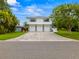 Two-story home with three-car garage and light-blue trim is set back from the street at 1731 Clearwater Harbor Dr, Largo, FL 33770