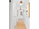 Bright hallway featuring hardwood floors, modern lighting, and stylish artwork at 1731 Clearwater Harbor Dr, Largo, FL 33770