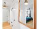 Hallway with light hardwood flooring, white doors and walls, and a bedroom visible in the mirror at 1731 Clearwater Harbor Dr, Largo, FL 33770
