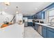Modern kitchen featuring stainless appliances, white countertop island with chairs, and blue cabinets at 1731 Clearwater Harbor Dr, Largo, FL 33770