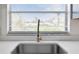 Close-up of a stainless steel kitchen sink with a stylish faucet and a window with blinds above it at 1731 Clearwater Harbor Dr, Largo, FL 33770