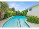 Backyard swimming pool with clear blue water, landscaped with a white concrete deck and patio area at 1731 Clearwater Harbor Dr, Largo, FL 33770