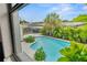 Backyard with a large inviting pool, mature landscaping, a barbecue and picnic area, and privacy fence at 1731 Clearwater Harbor Dr, Largo, FL 33770