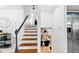 A staircase with hardwood steps, and a white banister, next to kitchen at 1731 Clearwater Harbor Dr, Largo, FL 33770