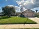 Charming single-story home with a well-manicured lawn, mature trees, and a two-car garage at 9223 Pebble Creek Dr, Tampa, FL 33647