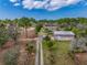 Expansive property featuring a home, large metal building, and a long driveway, surrounded by lush greenery and mature trees at 8279 Sunshine Grove Rd, Brooksville, FL 34613