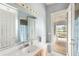 Bright bathroom with a white vanity, a large mirror, and a door that opens to the pool area at 8305 Welsford Rd, Port Charlotte, FL 33981