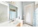 Bright bathroom featuring a large mirror, a single sink vanity, and a decorated glass door at 8305 Welsford Rd, Port Charlotte, FL 33981