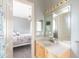 Bright bathroom featuring a large mirror, a single sink vanity, and a connecting bedroom at 8305 Welsford Rd, Port Charlotte, FL 33981