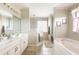 Serene bathroom with dual vanities, walk-in shower, soaking tub, and neutral color palette at 8305 Welsford Rd, Port Charlotte, FL 33981