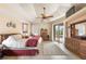Main bedroom featuring tray ceiling, neutral colors, and sliding doors leading to the pool area at 8305 Welsford Rd, Port Charlotte, FL 33981