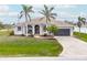 Charming home with palm trees, lovely landscaping, and a covered front porch at 8305 Welsford Rd, Port Charlotte, FL 33981