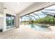 Enclosed pool and patio area featuring a jacuzzi, tile flooring and multiple entry ways at 8305 Welsford Rd, Port Charlotte, FL 33981