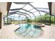 Enclosed pool area featuring a jacuzzi, tile flooring, multiple entry ways and beautiful landscaping at 8305 Welsford Rd, Port Charlotte, FL 33981