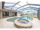 A backyard pool and spa with a screened enclosure and patio at 8305 Welsford Rd, Port Charlotte, FL 33981