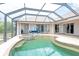 Enclosed pool area featuring a jacuzzi, tile flooring, multiple entry ways and outdoor seating at 8305 Welsford Rd, Port Charlotte, FL 33981