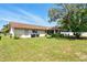 Spacious backyard featuring a well-maintained lawn, patio with grill, and mature trees providing ample shade at 5078 Kenmore St, Spring Hill, FL 34608