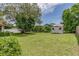 Large grassy backyard with a storage shed and mature trees offering shade at 5078 Kenmore St, Spring Hill, FL 34608