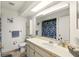 Bright bathroom featuring a large mirror, blue-themed decor, and a shower with a floral curtain at 5078 Kenmore St, Spring Hill, FL 34608