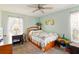 Comfortable bedroom with ceiling fan, desk, and a wooden-framed bed with storage underneath at 5078 Kenmore St, Spring Hill, FL 34608