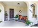 Inviting front porch with decorative wreath, outdoor seating, and colorful accent rug at 5078 Kenmore St, Spring Hill, FL 34608