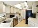 Compact kitchen with white cabinetry, stainless steel appliances, and a window view at 5078 Kenmore St, Spring Hill, FL 34608