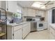 Bright kitchen featuring white cabinets, stainless steel appliances, and a ceiling fan at 5078 Kenmore St, Spring Hill, FL 34608