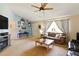 Carpeted living room with large window, ceiling fan, and stylish decor at 5078 Kenmore St, Spring Hill, FL 34608