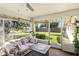 Sunroom with a comfortable sofa and an outdoor view of a large backyard at 5078 Kenmore St, Spring Hill, FL 34608