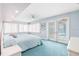 Light and airy bedroom with blue carpet, a ceiling fan, and access to the pool area through glass doors at 849 Harbor Is, Clearwater Beach, FL 33767