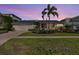 Charming single-story home with palm trees and a well-manicured lawn at sunset at 849 Harbor Is, Clearwater Beach, FL 33767