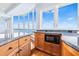 Kitchen featuring a breakfast bar, light wood cabinetry, granite countertops, and amazing views of the water at 849 Harbor Is, Clearwater Beach, FL 33767