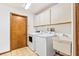 Functional laundry room with a washer, dryer, utility sink, and storage cabinets at 849 Harbor Is, Clearwater Beach, FL 33767