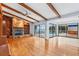 Spacious living room featuring a stone fireplace, wood beams, hardwood floors, and access to an outdoor pool area at 849 Harbor Is, Clearwater Beach, FL 33767