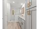 Bathroom featuring double sinks with white marbled counters, white cabinets, a shower, and modern lighting at 14183 English Sparrow Rd, Weeki Wachee, FL 34614