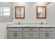 Bathroom featuring double sinks, modern wood-look framed mirrors, and white marble countertops at 14183 English Sparrow Rd, Weeki Wachee, FL 34614
