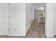 Hallway with light gray hardwood floors, white walls and view of the kitchen at the end at 14183 English Sparrow Rd, Weeki Wachee, FL 34614