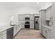 Open kitchen with gray cabinets, stainless steel appliances, marble countertops, and wood flooring at 14183 English Sparrow Rd, Weeki Wachee, FL 34614