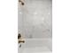 Modern bathtub featuring marble tiled walls and brushed gold hardware at 14183 English Sparrow Rd, Weeki Wachee, FL 34614