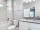Modern bathroom featuring marble tiling, a granite vanity, and a combined shower-tub at 2576 Pecan St, North Port, FL 34287