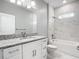 Modern bathroom featuring a granite countertop, white cabinets, and a tub with white marble tiling at 2576 Pecan St, North Port, FL 34287