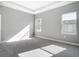 Neutral bedroom featuring carpet, two windows with natural light, and a tray ceiling at 2576 Pecan St, North Port, FL 34287