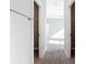 Hallway with carpeted floors, white doors, and easy access to bedrooms and closet spaces at 2576 Pecan St, North Port, FL 34287