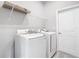 Functional laundry room with washer and dryer, shelving, and vinyl floors at 2576 Pecan St, North Port, FL 34287