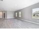 Spacious living area with three windows, hard surface floors, and neutral color palette at 2576 Pecan St, North Port, FL 34287