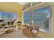 Bright breakfast nook with rattan table set, yellow walls, and natural light from large windows at 4446 Bahama Dr, Hernando Beach, FL 34607