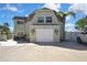 Charming house featuring a two-car garage, palm trees, a gable roof, and coastal decor at 4446 Bahama Dr, Hernando Beach, FL 34607