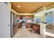 Well-lit kitchen with stainless steel appliances, wooden cabinets, tile backsplash, and breakfast nook with water views at 4446 Bahama Dr, Hernando Beach, FL 34607